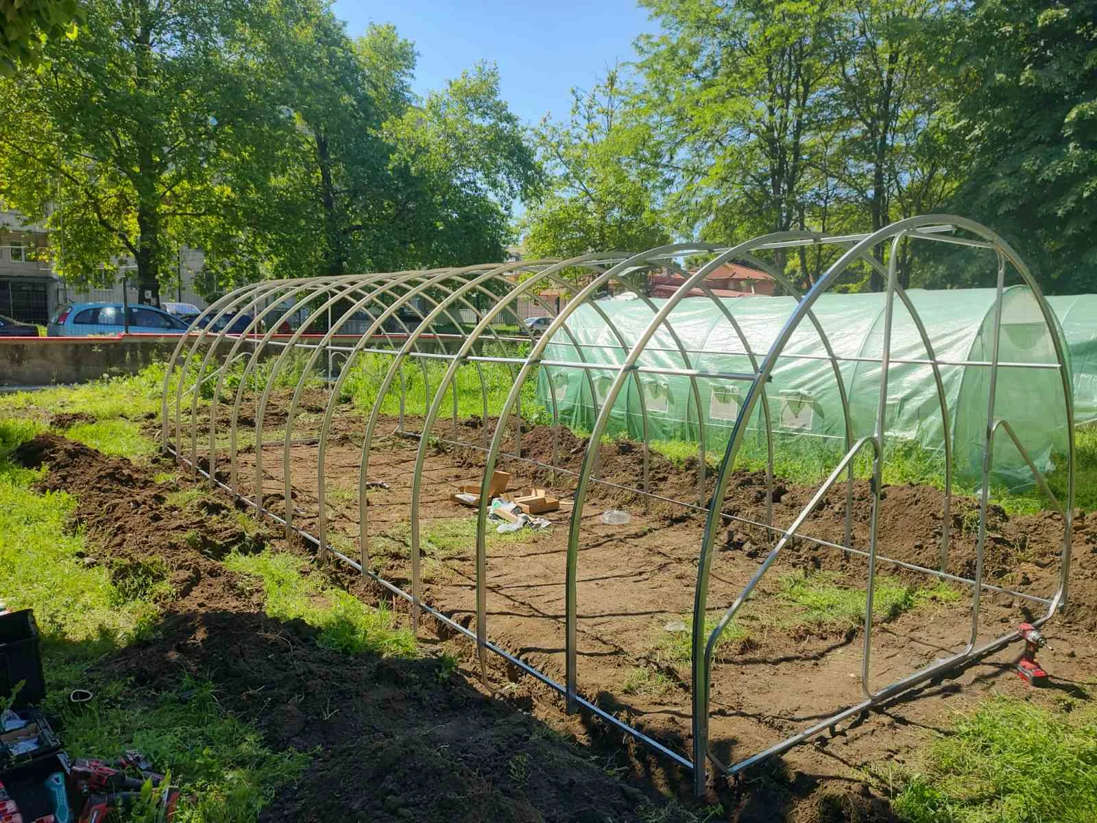 Uncovered greenhouse frame assembled over a garden bed